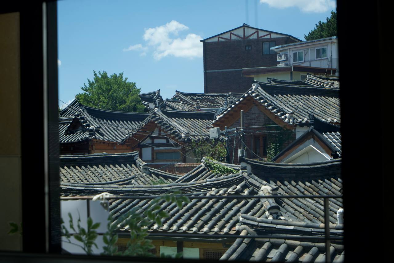 Hanok rooftops beneath a blue sky